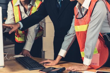 Depo müdürü ve işçisi depoda çalışıyor.