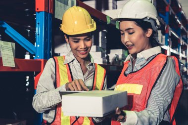 Depoda çalışan kadın bir depo işçisi.