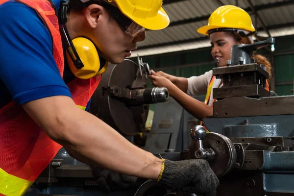 Groupe de travailleurs habiles utilisant des équipements de machine dans l'atelier d'usine — Photo