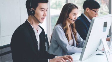 Ofiste çalışan kulaklık takan iş adamları.