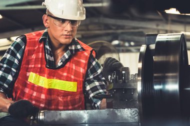 Akıllı fabrika işçisi veya mühendisi bir imalat atölyesinde makine işi yapıyor.