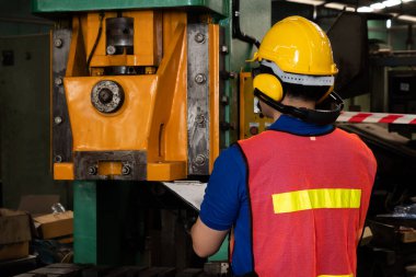 Fabrika işçisi veya mühendisi imalat atölyesinde makine işi yapıyor.