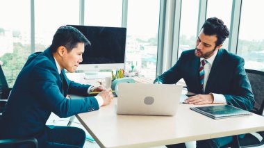 İki iş adamı ofiste proje stratejisi hakkında konuşuyor