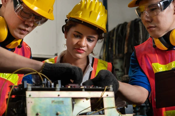 Groupe de travailleurs habiles utilisant des équipements de machine dans l'atelier d'usine — Photo