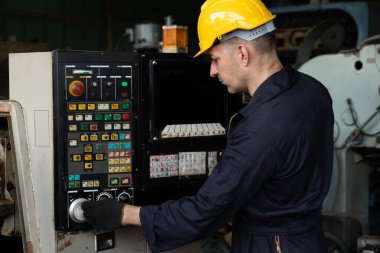 Fabrika mühendisi veya işçisi üretim atölyesinde makine işi yapıyor.