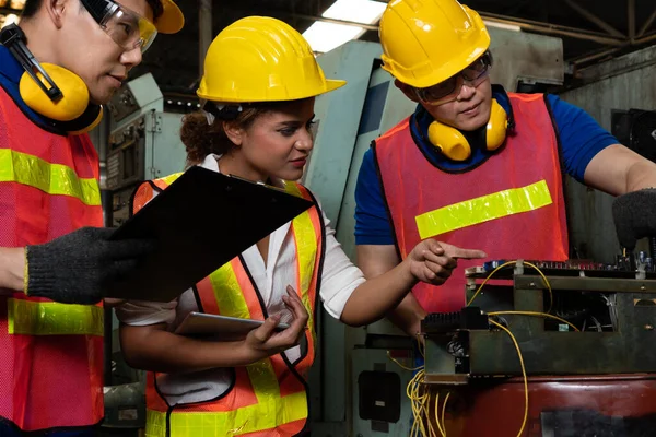 Grupo de trabalhadores habilidosos usando equipamentos de máquinas na oficina de fábrica — Fotografia de Stock