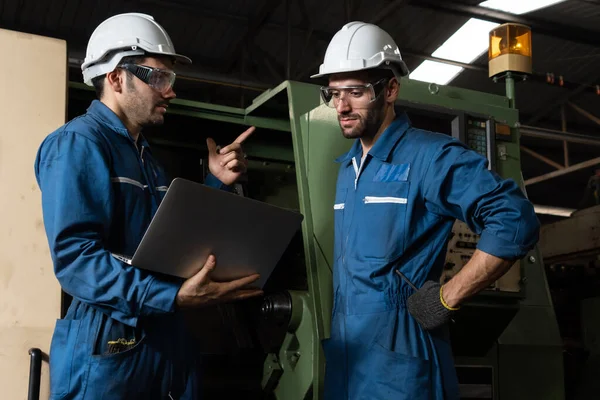 Gruppo di operai qualificati che utilizzano attrezzature per macchine in officina — Foto Stock