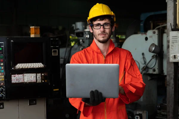 Travailleur d'usine compétent travaillant avec un ordinateur portable pour faire la liste de vérification de la procédure . — Photo