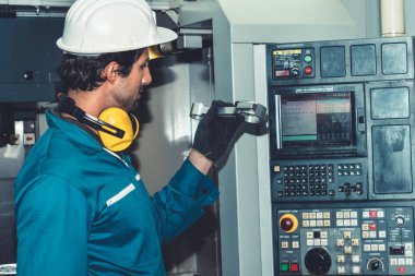 Akıllı fabrika işçisi veya mühendisi imalat atölyesinde makine işi yapıyor.