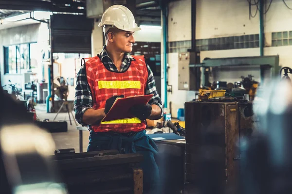 Trabalhador de fabricação que trabalha com área de transferência para fazer a lista de verificação do procedimento de trabalho . — Fotografia de Stock