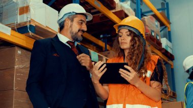 Depo müdürü depodaki işçiyle görüşüyor.