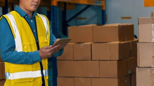 Asian warehouse worker checking packages in storehouse