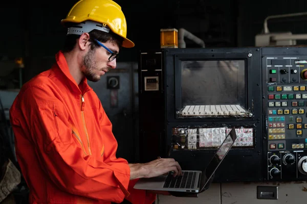 Travailleur d'usine compétent travaillant avec un ordinateur portable pour faire la liste de vérification de la procédure . — Photo