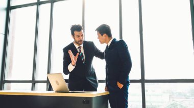 İki iş adamı ofiste proje stratejisi hakkında konuşuyor