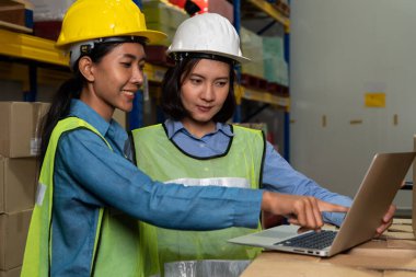 Depoda çalışan kadın bir depo işçisi.