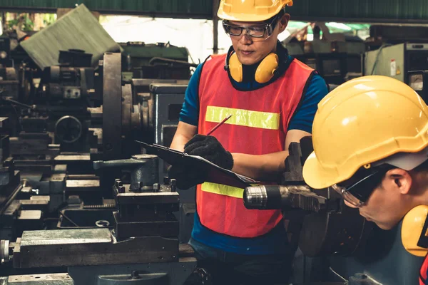 Grupo de trabalhadores de fábrica habilidosos usando equipamentos de máquinas em oficina — Fotografia de Stock