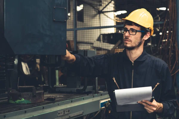 Kompetent fabriksarbetare som arbetar med urklipp för att göra jobbet förfarande checklista . — Stockfoto