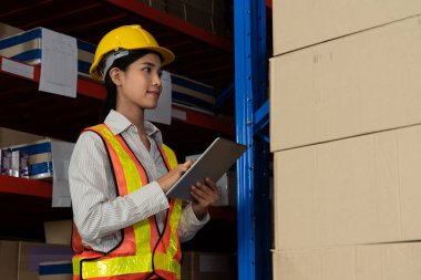 Depoda çalışan kadın bir depo işçisi.