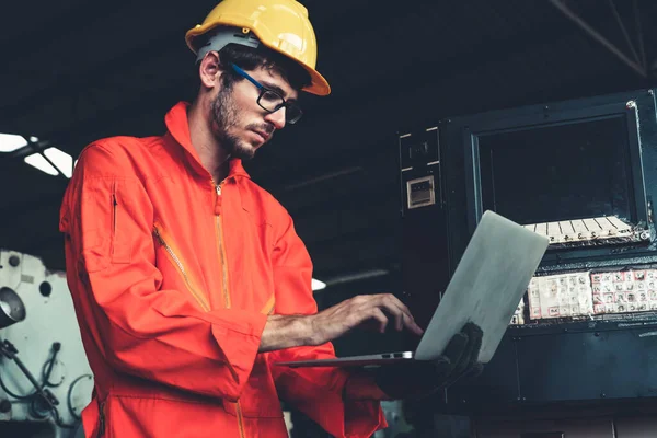 Trabalhador de fábrica hábil trabalhando com computador portátil para fazer a lista de verificação do procedimento . — Fotografia de Stock