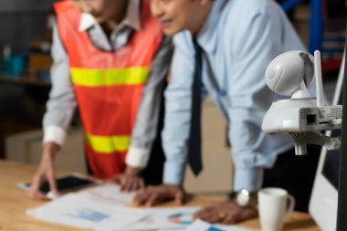 Depoda çalışan depo çalışanlarını izleyen güvenlik kamerası.