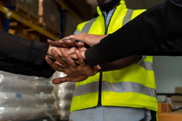Trabalhadores da fábrica empilhando as mãos juntas em armazém ou armazém — Fotografia de Stock