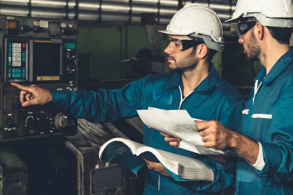 Grupp skickliga fabriksarbetare som använder maskinutrustning i verkstaden — Stockfoto