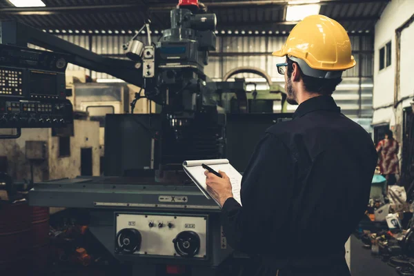 Abile operaio di fabbrica che lavora con appunti per fare procedura di lavoro lista di controllo . — Foto Stock