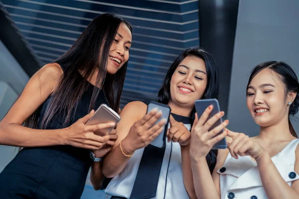 Drei Freundinnen chatten mit Mobiltelefon. — Stockfoto