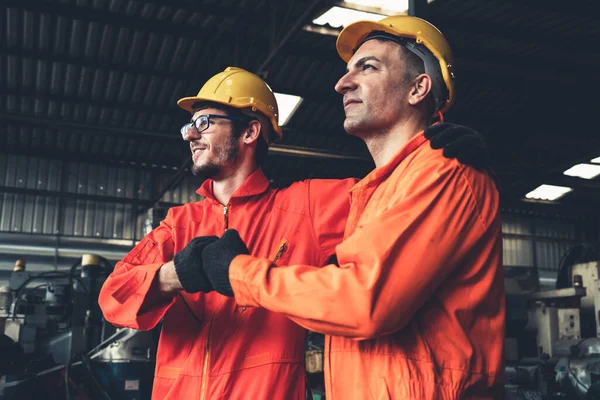 Dos hábiles ingenieros de fábrica o trabajadores que muestran trabajo en equipo y asociación . — Foto de Stock