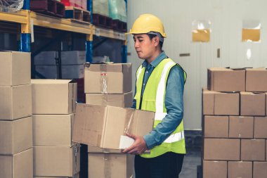 Asyalı depo işçisi depodaki paketleri kontrol ediyor