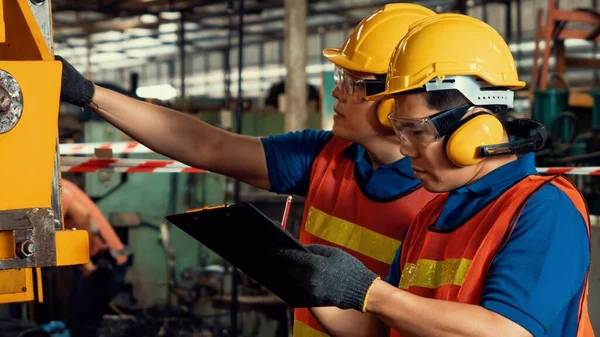 Groep bekwame fabrieksarbeiders die machineapparatuur gebruiken in de werkplaats — Stockfoto