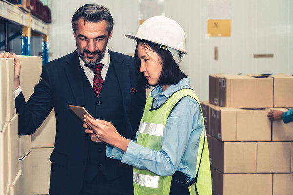 Старший менеджер склада обсуждает с работником на складе