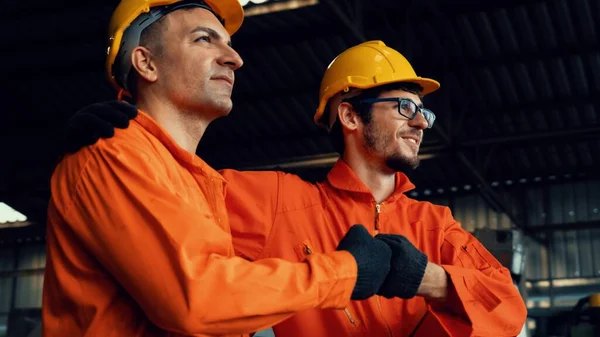 Dos hábiles ingenieros de fábrica o trabajadores que muestran trabajo en equipo y asociación . — Foto de Stock