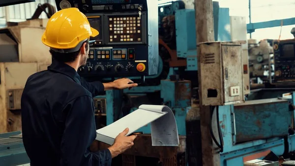 Travailleur d'usine habile travaillant avec presse-papiers pour faire la liste de contrôle de procédure de travail . — Photo