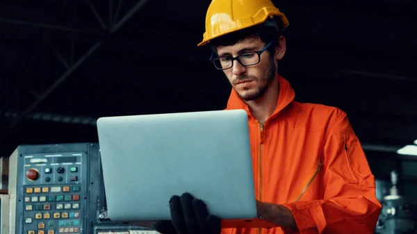 Travailleur d'usine compétent travaillant avec un ordinateur portable pour faire la liste de vérification de la procédure . — Photo