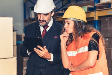 Depo müdürü depodaki işçiyle görüşüyor.