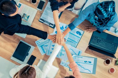 Takım çalışması çalışanları toplantıda el ele tutuşuyor.