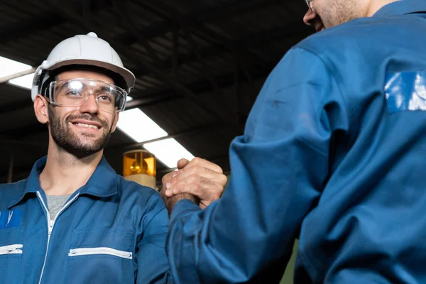 Two skillful factory engineer or worker showing teamwork and partnership .