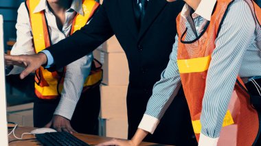 Depo müdürü ve işçisi depoda çalışıyor.