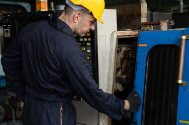 Fabrika mühendisi veya işçisi üretim atölyesinde makine işi yapıyor.