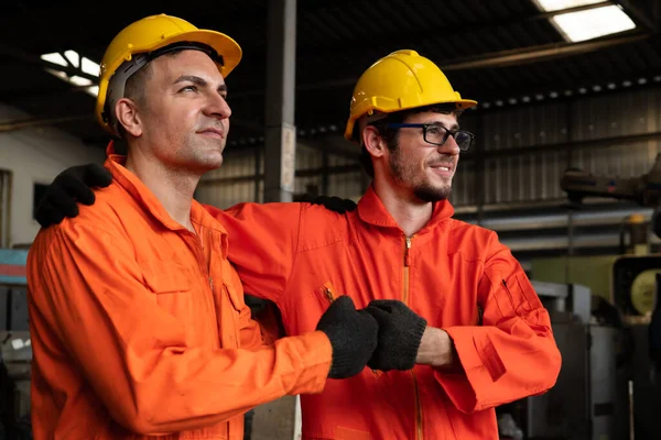 Dos hábiles ingenieros de fábrica o trabajadores que muestran trabajo en equipo y asociación . — Foto de Stock