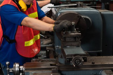 Fabrika işçisi veya mühendisi imalat atölyesinde makine işi yapıyor.