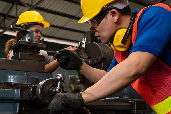 Groupe de travailleurs habiles utilisant des équipements de machine dans l'atelier d'usine — Photo