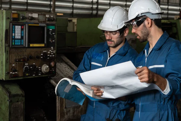 Grupo de trabalhadores de fábrica habilidosos usando equipamentos de máquinas em oficina — Fotografia de Stock