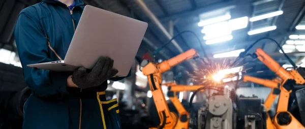 Ingenjör använder avancerad robotprogramvara för att styra industrin robot arm i fabriken — Stockfoto