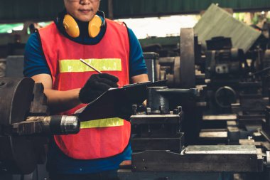 İşlemleri kontrol etmek için pano ile çalışan yetenekli bir fabrika işçisi. .