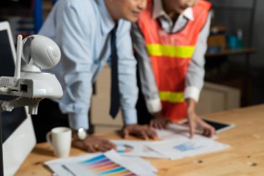 Depoda çalışan depo çalışanlarını izleyen güvenlik kamerası.