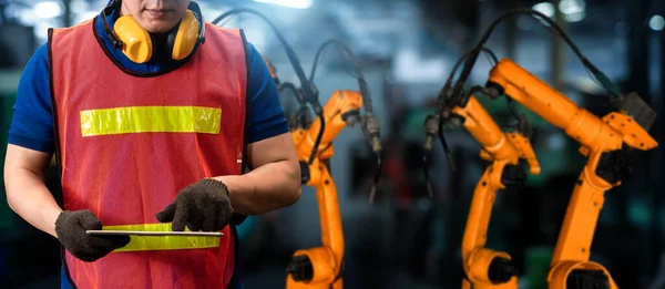 L'ingénieur utilise un logiciel robotique avancé pour contrôler le bras robotisé de l'industrie en usine — Photo