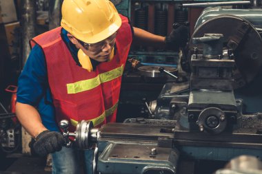 Fabrika işçisi veya mühendisi imalat atölyesinde makine işi yapıyor.