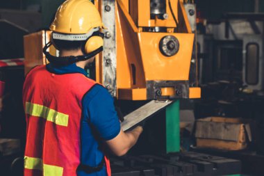 Fabrika işçisi veya mühendisi imalat atölyesinde makine işi yapıyor.